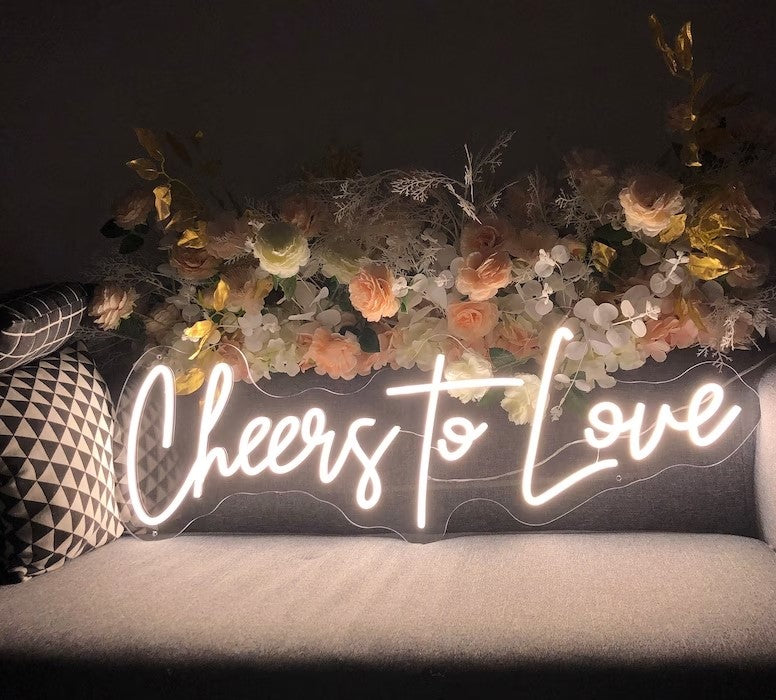 Click to view full size Raise a glass to love with the Cheers To Love wedding neon sign from ManhattanNeons.com, adding a celebratory glow to your big day